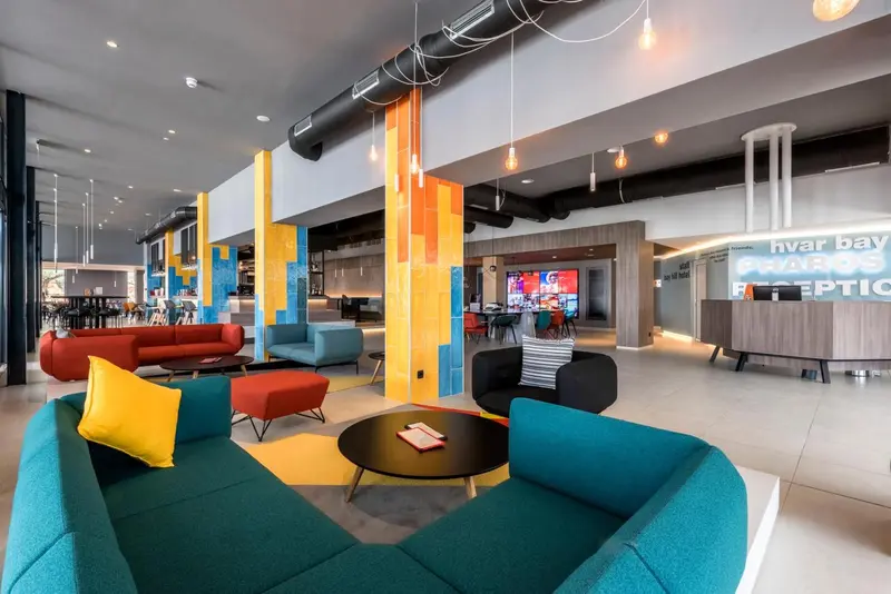 Espace de détente coloré avec canapés et tables basses dans un hall d'accueil.