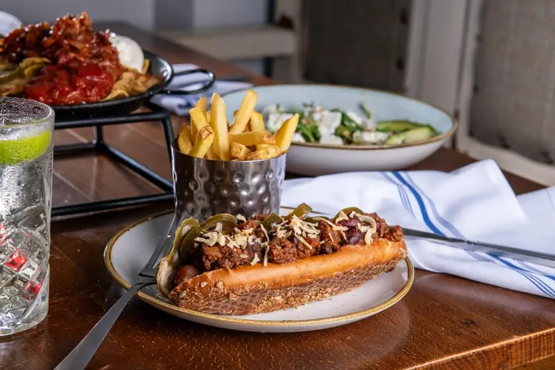 Assiettes garnies de frites, de salade et de hot-dogs servis dans un restaurant.