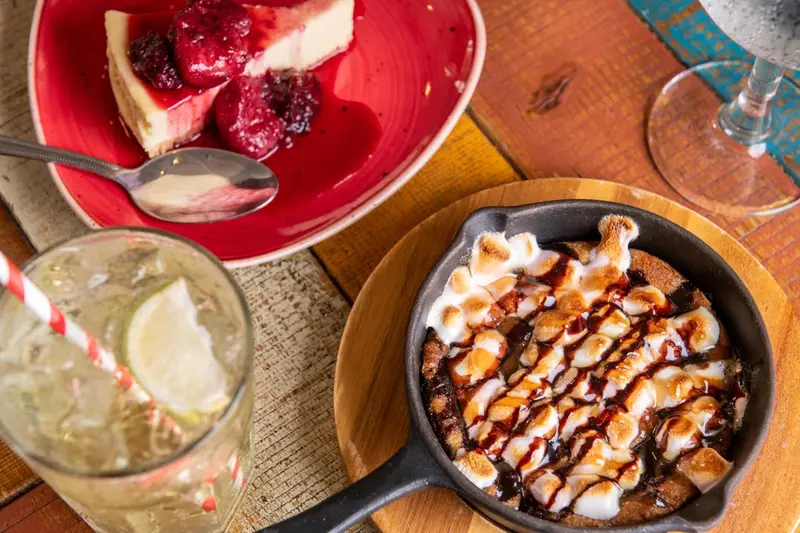 Assiette de cheesecake aux fruits rouges et dessert au chocolat servis sur une table en bois.