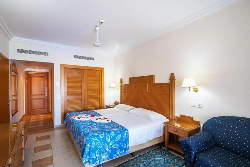 Une chambre lumineuse avec un grand lit et un coin salon.