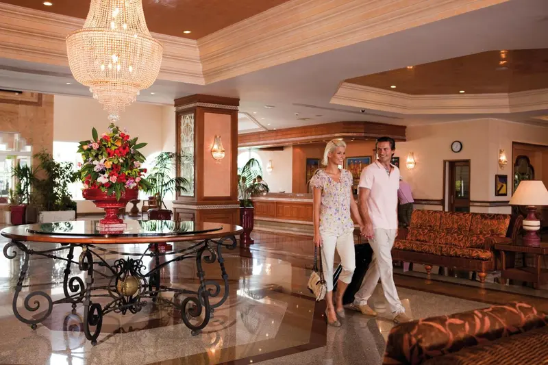 Un couple se promène dans un hall d'hôtel spacieux et lumineux.