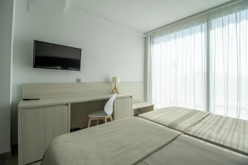 Une chambre lumineuse avec un bureau et un lit.
