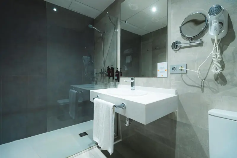 Une salle de bain moderne avec douche à l'italienne et miroir.
