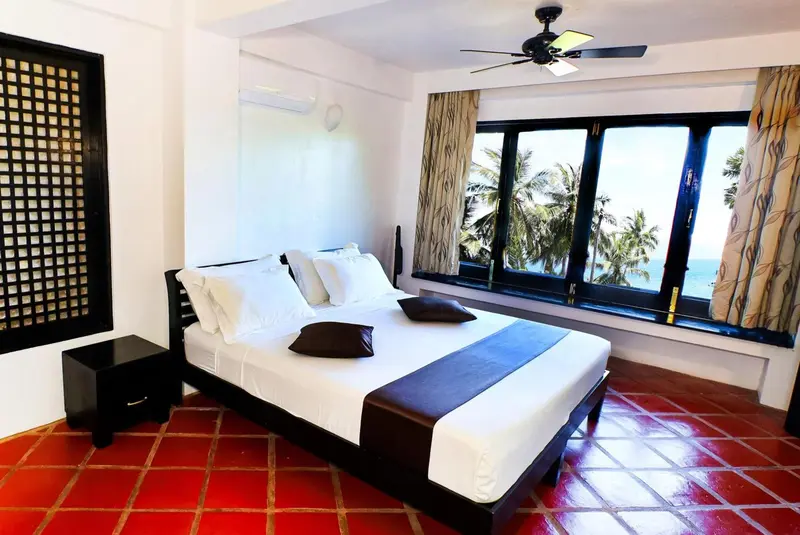 Une chambre lumineuse avec un grand lit et une vue sur la mer.