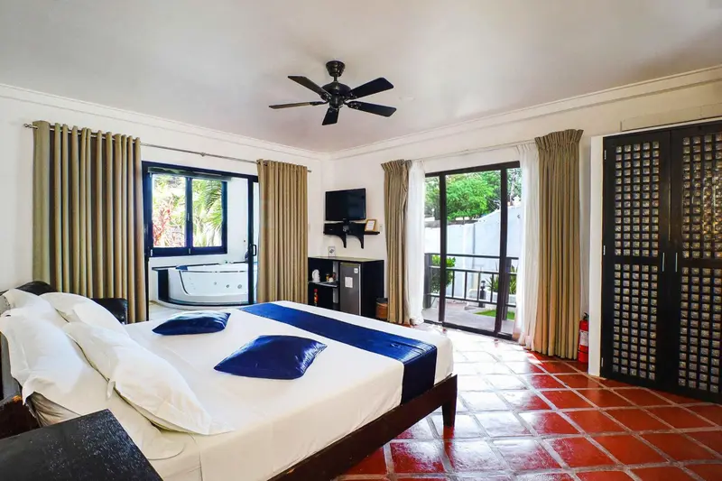 Une chambre lumineuse avec un grand lit et un accès à une terrasse.