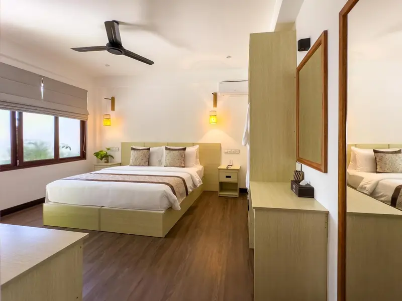 Une chambre lumineuse avec un grand lit et un mobilier en bois clair.