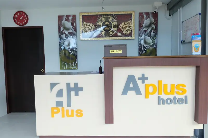 Un comptoir d'accueil moderne avec un décor mural abstrait et une horloge.
