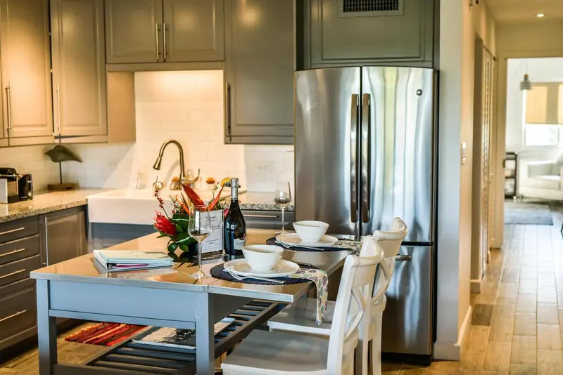 Une cuisine moderne avec un îlot central et une table pour deux.