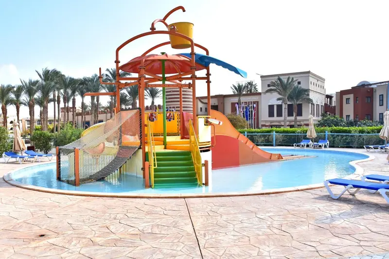 Structure de jeux colorée au bord d'une piscine ensoleillée.