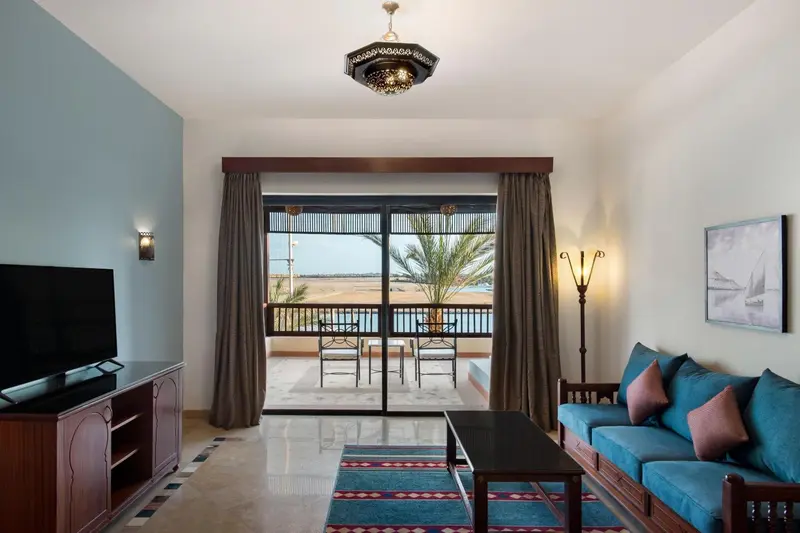 Un salon lumineux s'ouvre sur une terrasse avec vue sur la végétation.
