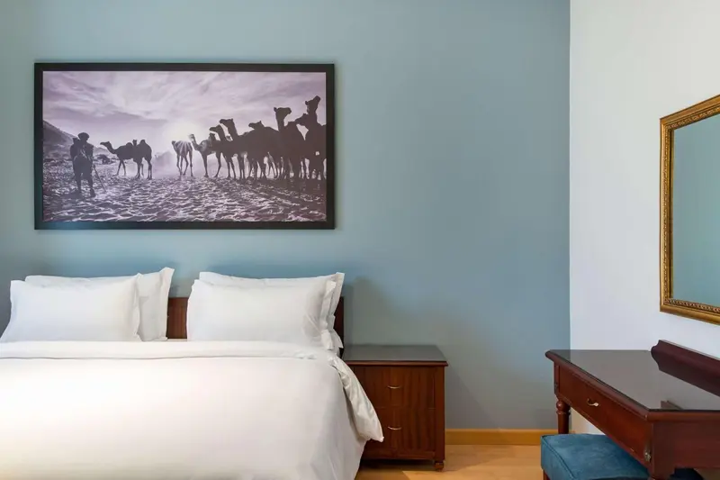Une chambre d'hôtel avec un lit blanc et une décoration murale.