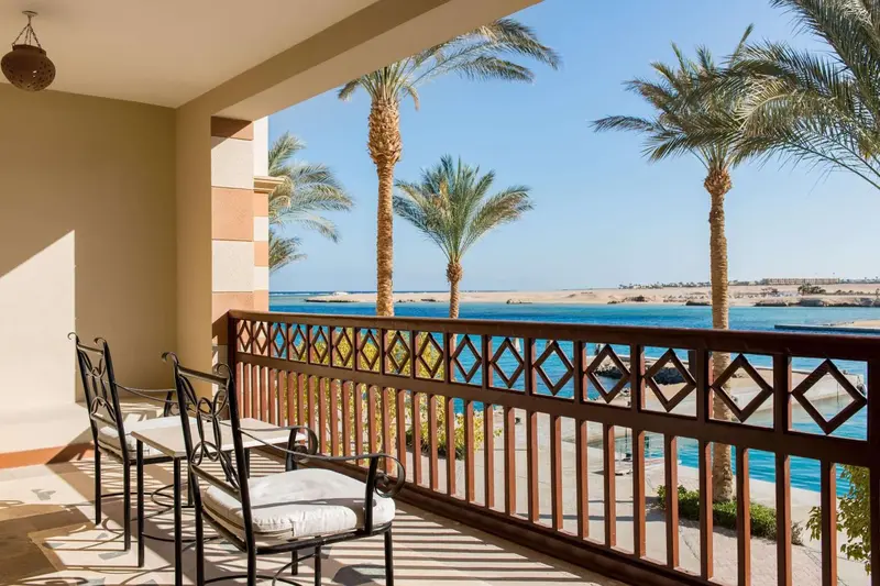 Terrasse avec mobilier d'extérieur donnant sur la mer et la végétation.