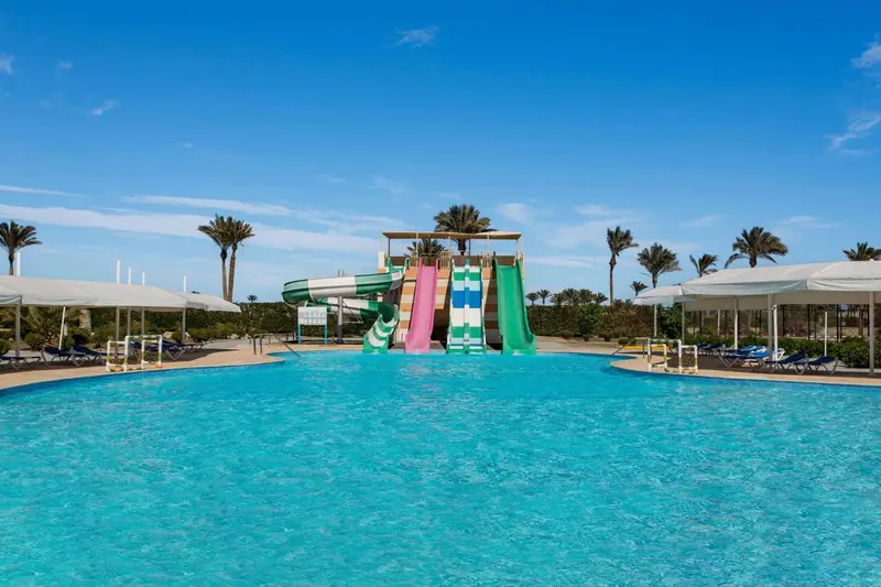 Une piscine avec des toboggans aquatiques sous un ciel bleu dégagé.