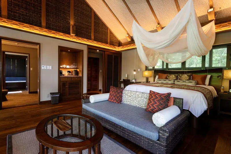 Une chambre spacieuse avec un lit à baldaquin et un canapé.