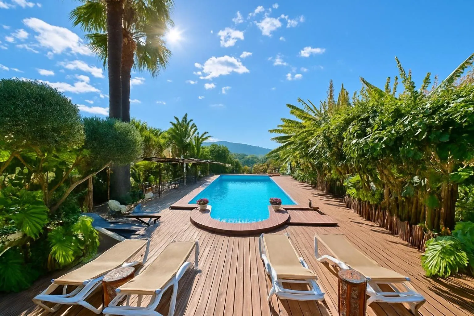 Transats alignés sur une terrasse en bois bordant une piscine rectangulaire.
