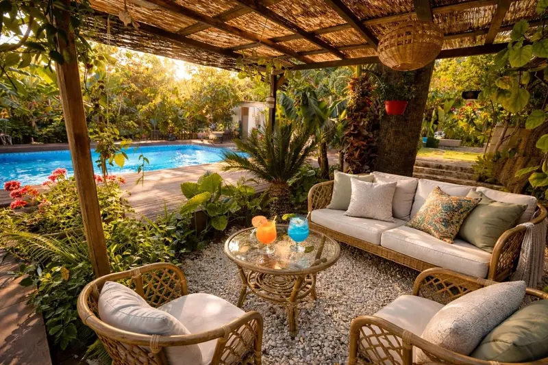 Salon de jardin avec canapés et table basse dans un cadre tropical.