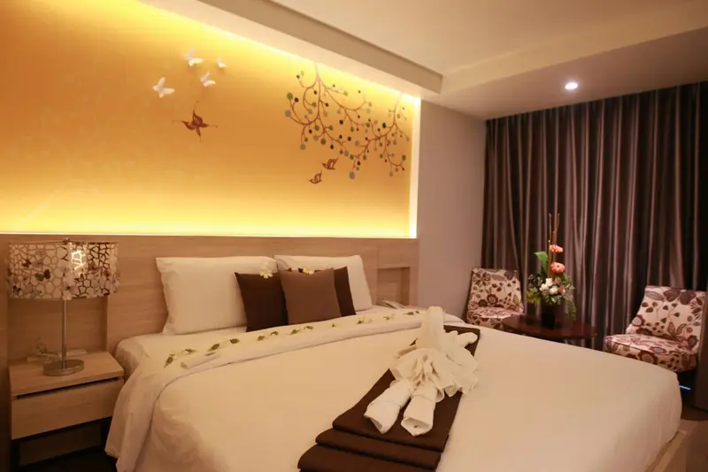 Une chambre d'hotel avec un lit soigneusement fait et une décoration florale.