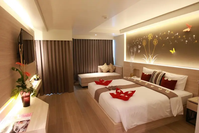 Une chambre lumineuse avec un grand lit et un coin salon.