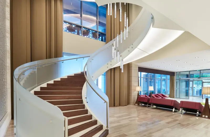 Un escalier en colimaçon moderne mène à un espace lumineux et ouvert.