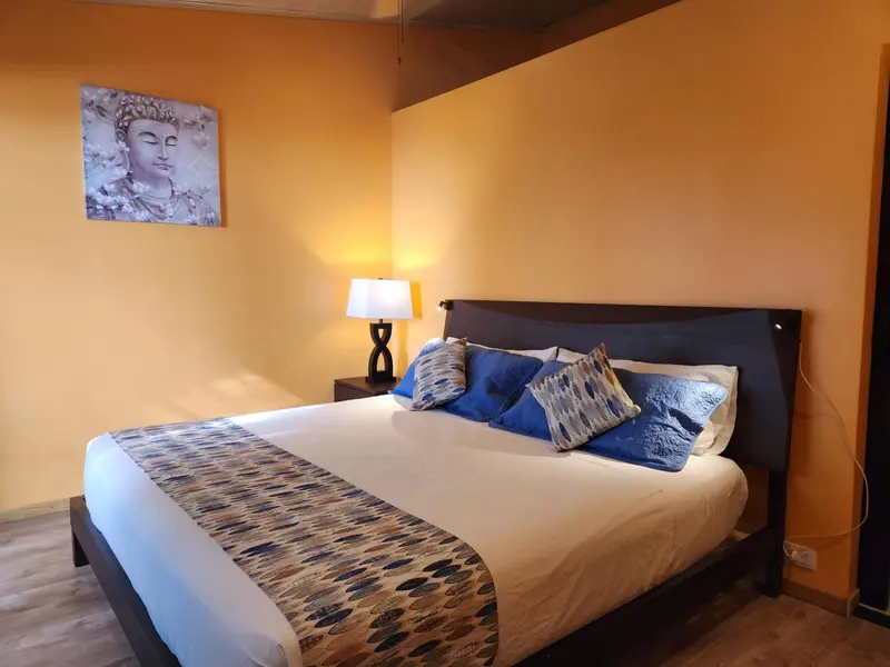 Une chambre lumineuse avec un grand lit décoré de coussins bleus.