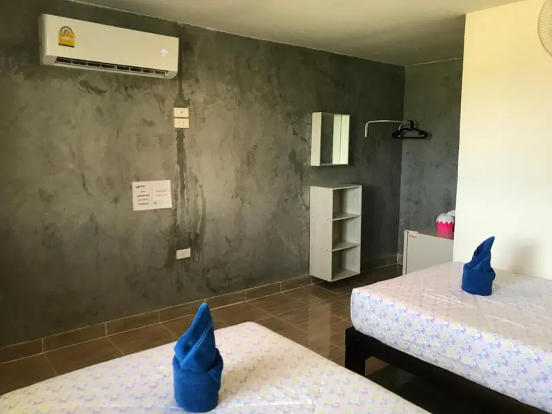 Une chambre avec deux lits simples et un meuble de rangement.