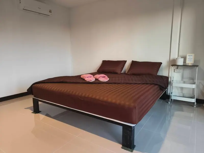 Une chambre avec un grand lit et une table de chevet.