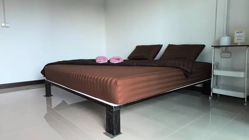Une chambre avec un lit double et une table de chevet.