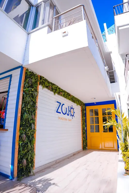 Façade d'un bâtiment blanc et bleu avec une entrée jaune.