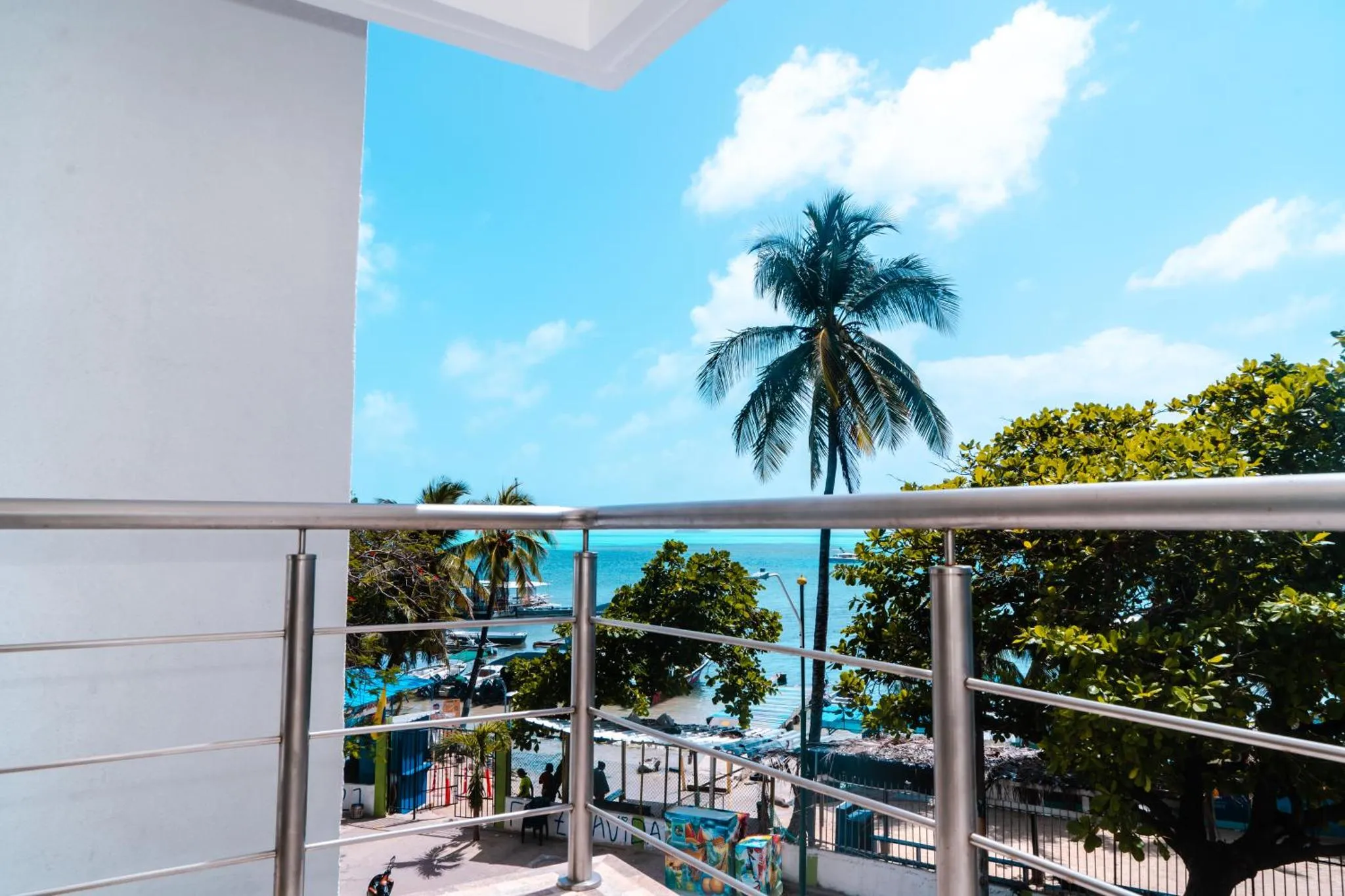 Vue sur la mer et la végétation depuis un balcon.