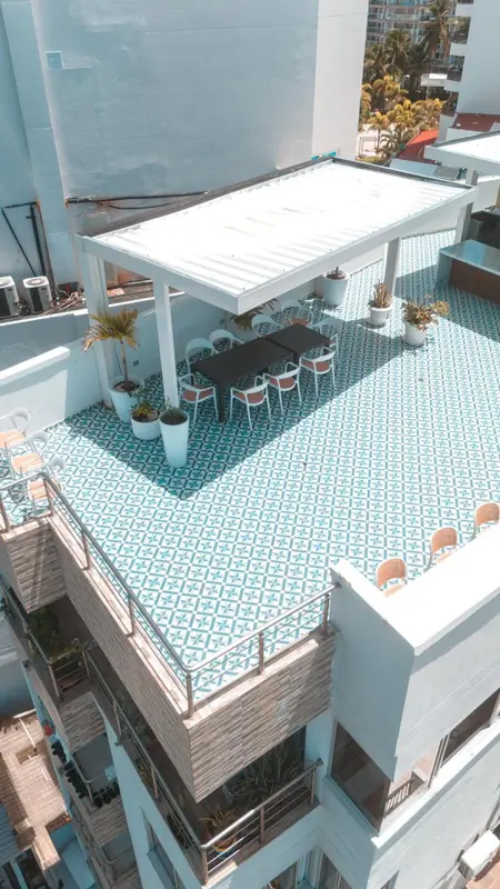 Terrasse carrelée avec mobilier de jardin et pergola.