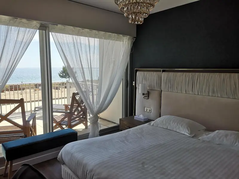 Une chambre lumineuse avec un grand lit donnant sur la mer.