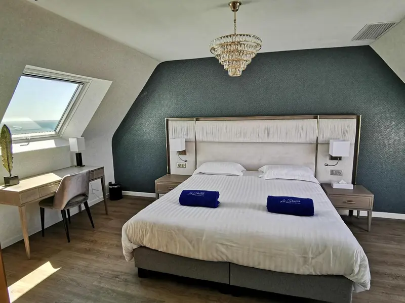 Une chambre lumineuse avec un grand lit et un bureau.