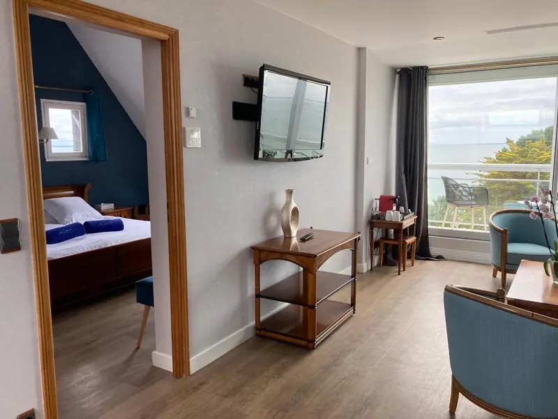 Une chambre lumineuse s'ouvre sur une terrasse avec vue sur la mer.