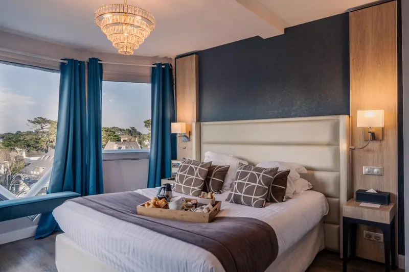Une chambre lumineuse avec un grand lit et un plateau de petit-déjeuner.