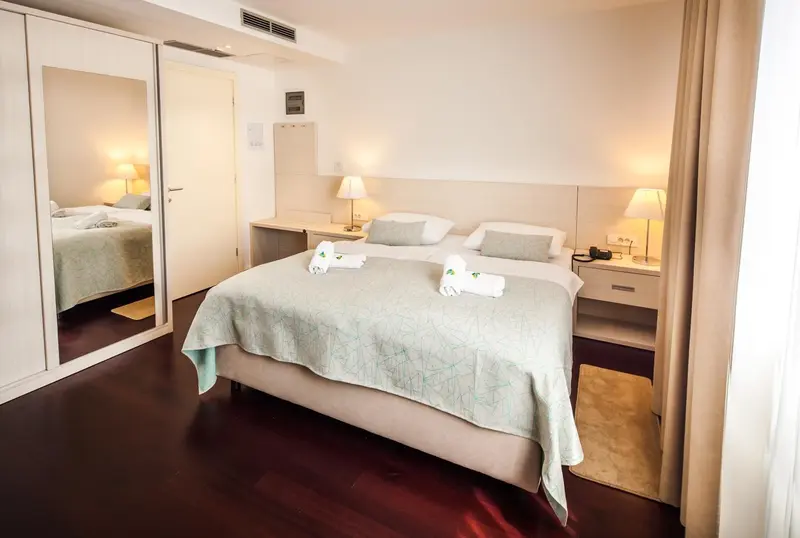 Une chambre lumineuse avec un grand lit et un miroir.