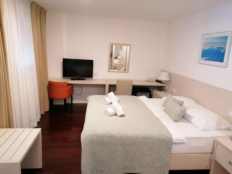 Une chambre lumineuse avec un lit double et un bureau.