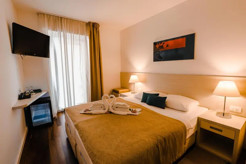 Une chambre d'hôtel lumineuse avec un grand lit et des lampes de chevet.