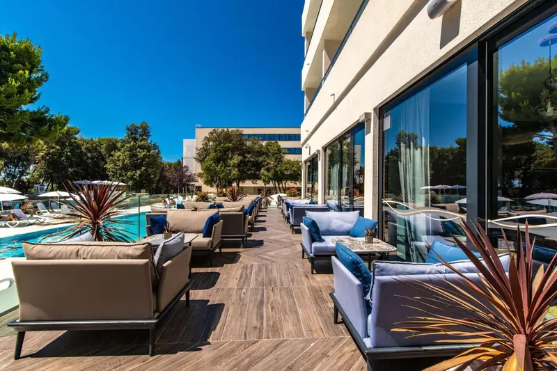 Terrasse aménagée avec des salons confortables et une piscine au premier plan.