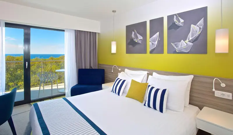 Une chambre lumineuse avec un grand lit et une vue sur la mer.