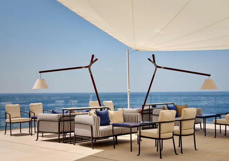 Espace de détente extérieur avec mobilier confortable et vue sur la mer.