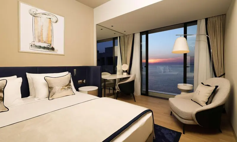 Une chambre lumineuse avec un grand lit et une vue sur la mer.