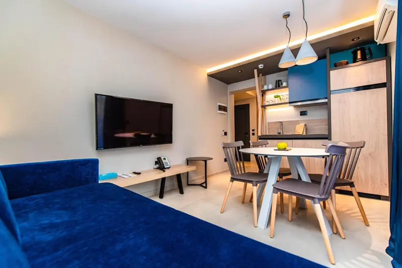 Un espace de vie lumineux avec un canapé bleu et une table à manger.