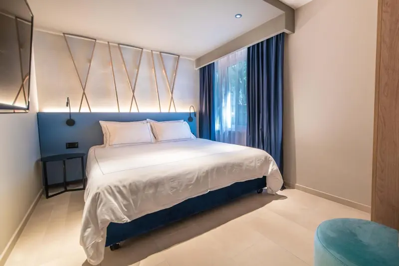 Une chambre lumineuse avec un grand lit recouvert de draps blancs.