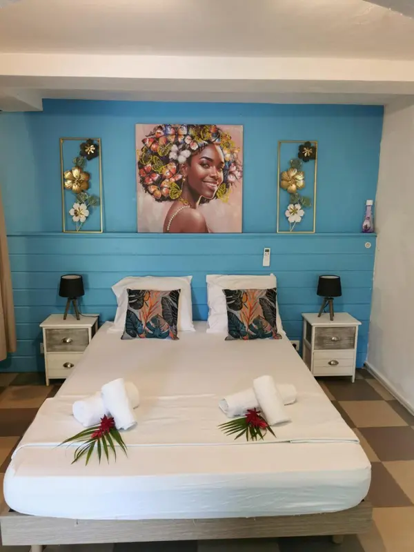 Une chambre lumineuse avec un grand lit décoré de fleurs.