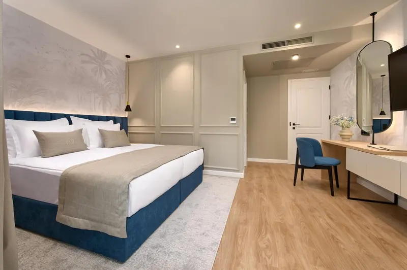 Une chambre lumineuse avec un grand lit et un coin bureau.