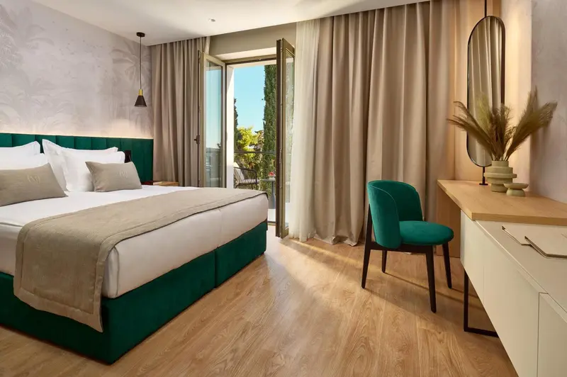 Une chambre lumineuse avec un grand lit et un coin salon.