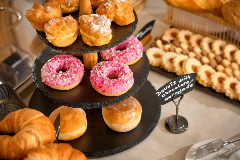 Assortiment de viennoiseries et de pâtisseries présentées sur un présentoir.