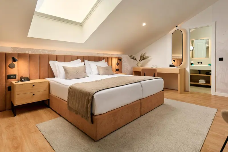 Une chambre lumineuse avec un grand lit et un bureau.
