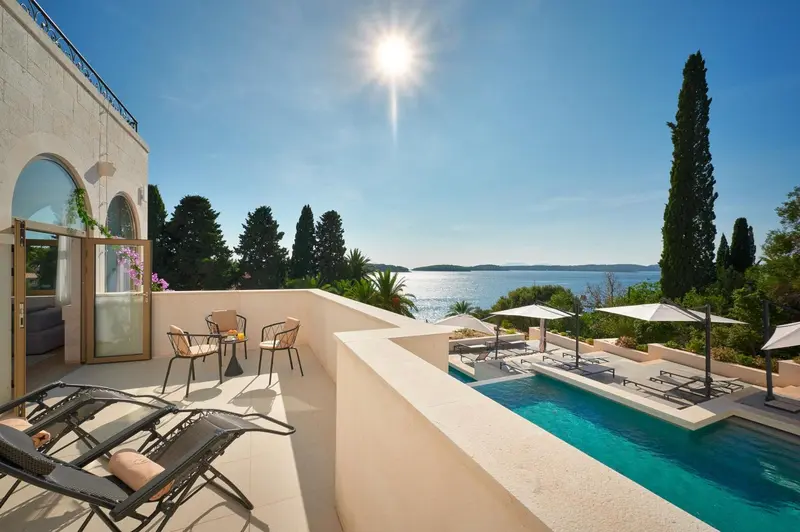 Terrasse avec mobilier de jardin et piscine donnant sur la mer.