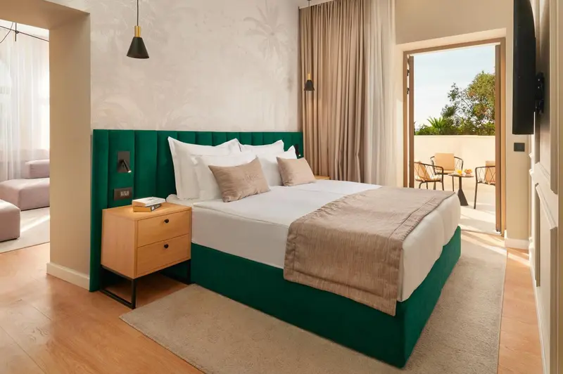 Une chambre lumineuse avec un grand lit et un accès à une terrasse.